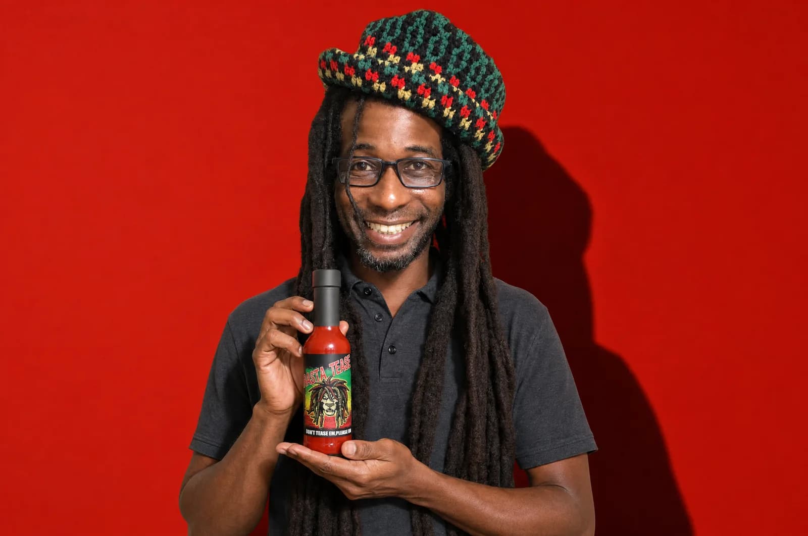 Peewee Dread holding a bottle of Rasta Tease hot sauce